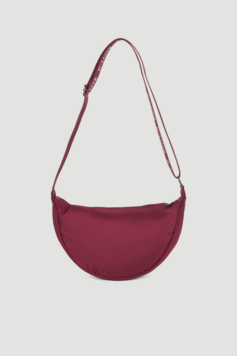 Plum-colored half moon crossbody bag with adjustable strap featuring discreet brand lettering for stylish everyday use
