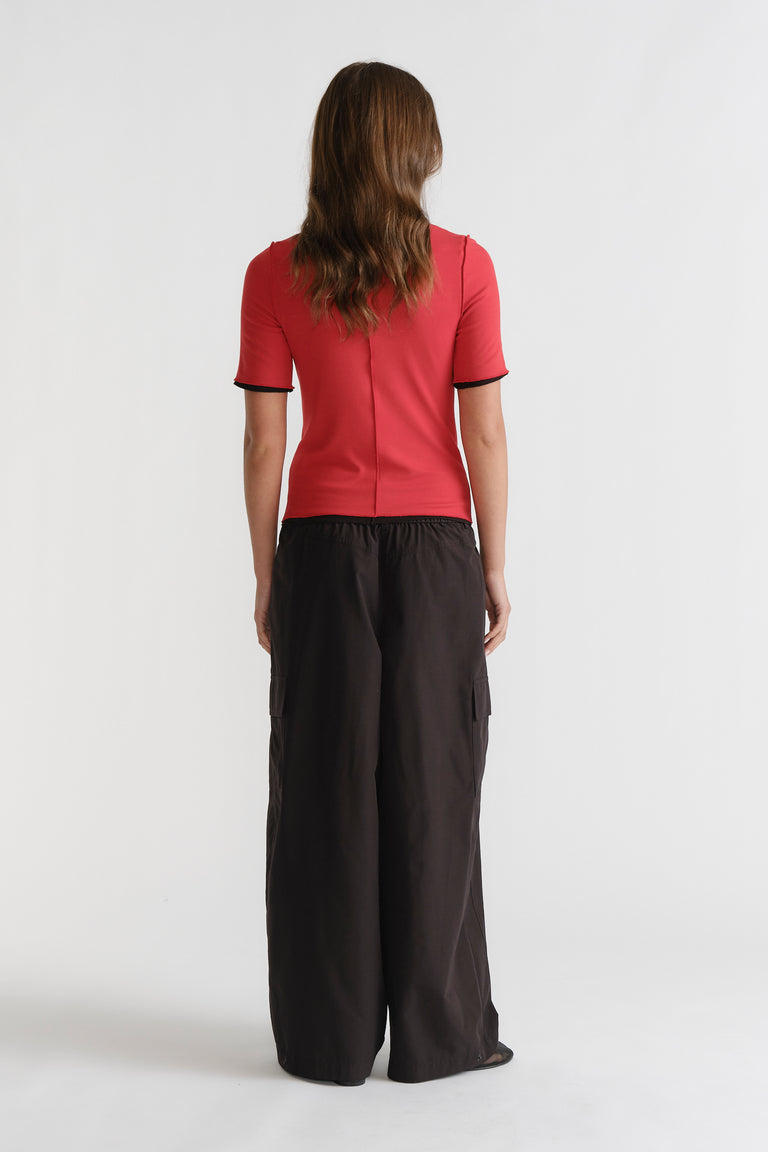 D-Luxe Short Sleeve Top in vibrant red with black trim, slim fit, styled with loose black pants by DECJUBA Australian fashion brand