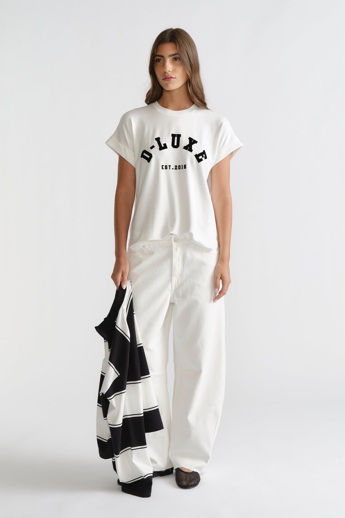 D-Luxe Half Moon Tee in white with bold black lettering, styled with relaxed white wide-leg denim by DECJUBA Australian brand.