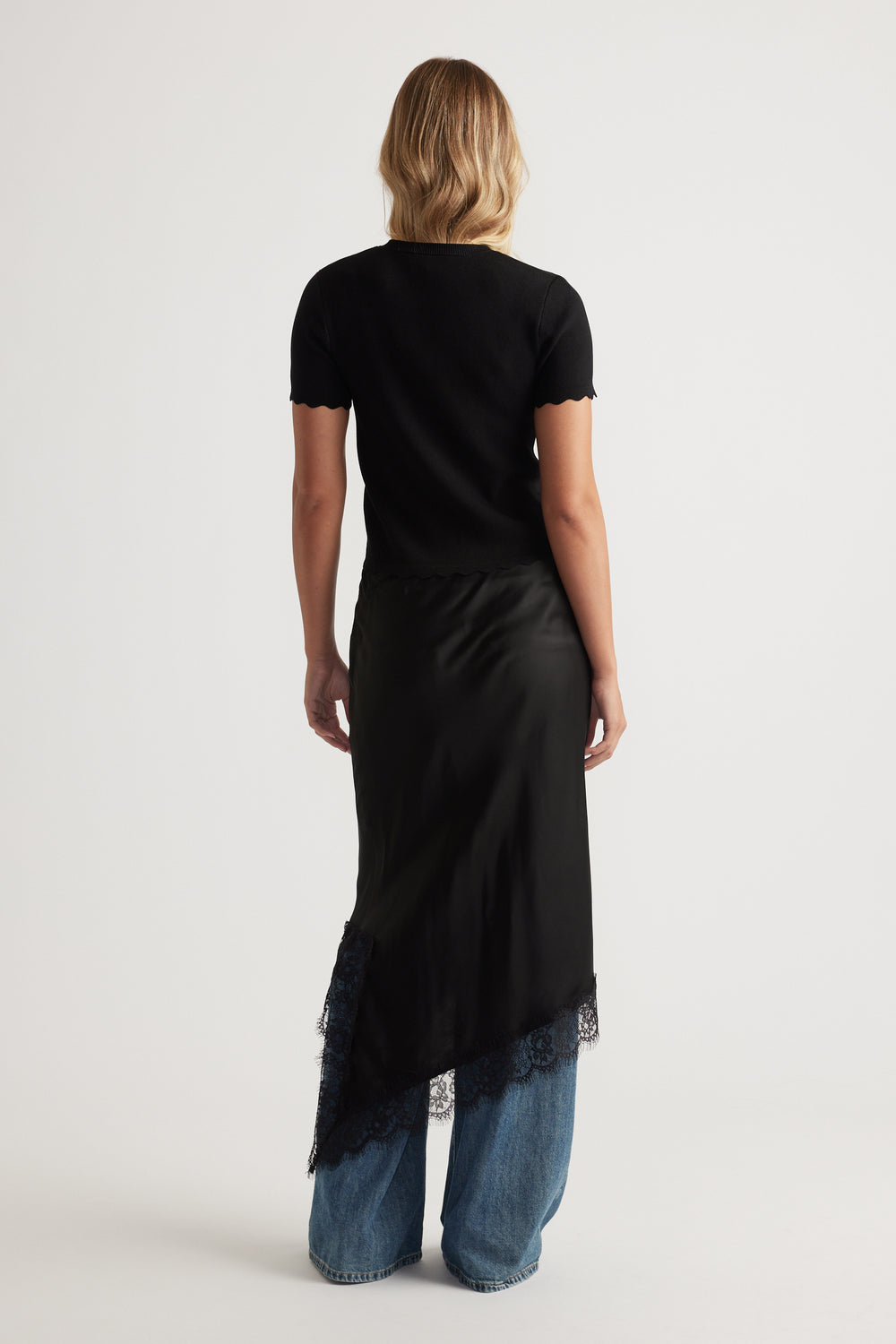 Back view of Maya Scallop Trim Button Top in black with subtle scalloped edges paired with wide-leg denim jeans