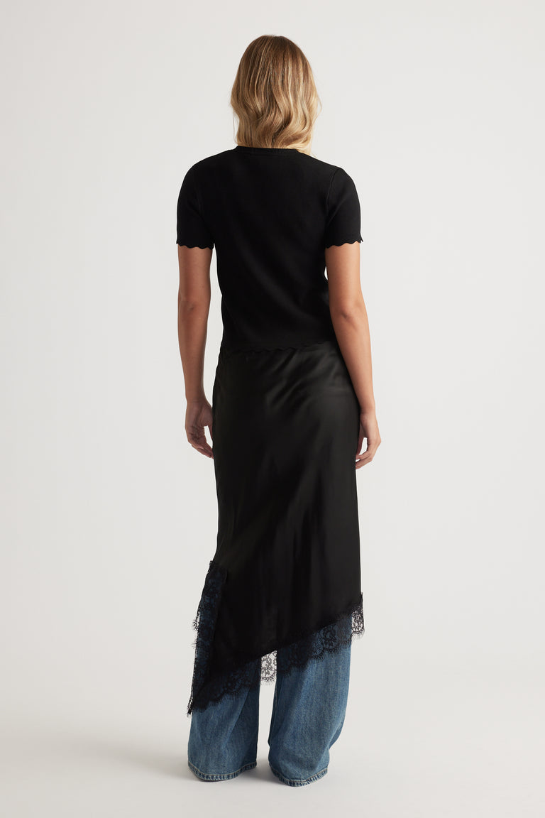 Back view of Maya Scallop Trim Button Top in black with subtle scalloped edges paired with wide-leg denim jeans