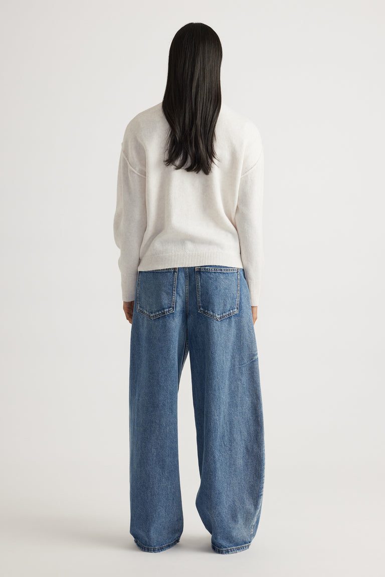 Back view of Crew Neck Knit Jumper in soft cream knitwear paired with relaxed wide-leg denim jeans by Decjuba fashion brand
