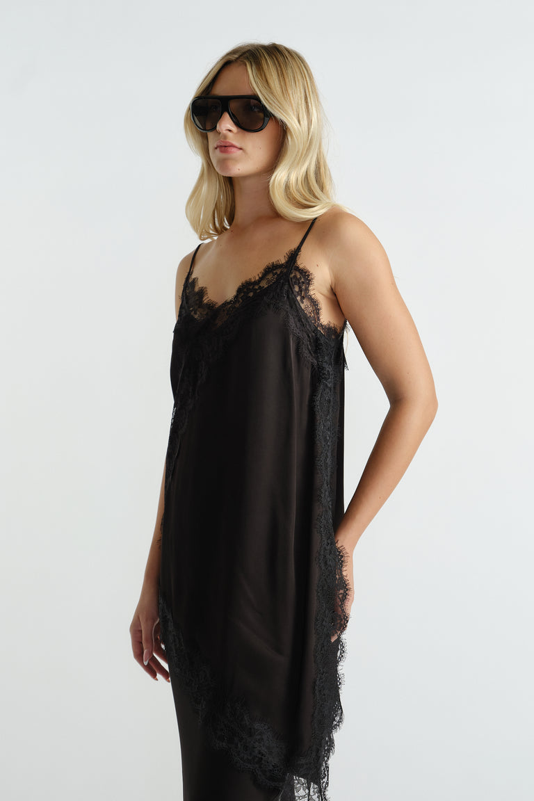 Woman wearing a black lace-trimmed slip dress with thin straps and oversized sunglasses for a chic look