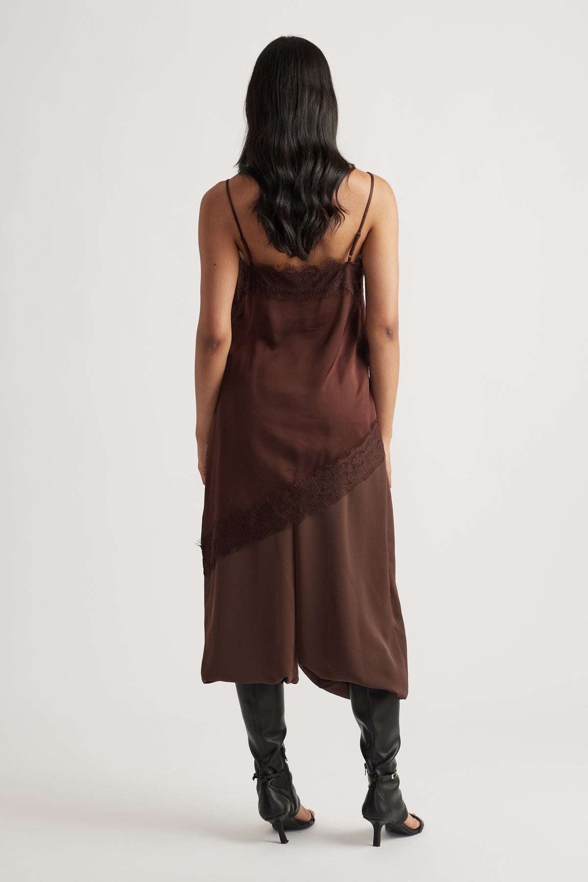 Back view of woman wearing Karla Lace Tunic in rich brown with lace trim, styled with black heeled boots by DECJUBA Australian brand