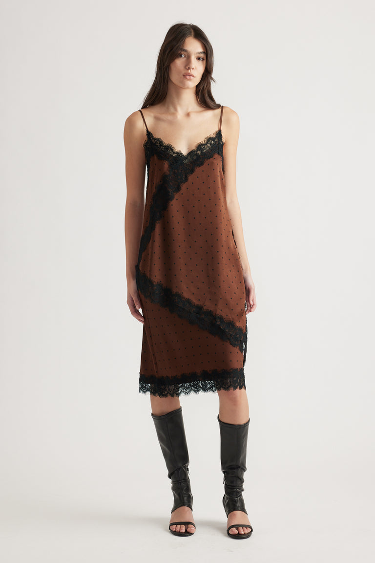 Woman wearing a brown slip dress with black lace trim and thin straps paired with black open-toe knee-high boots