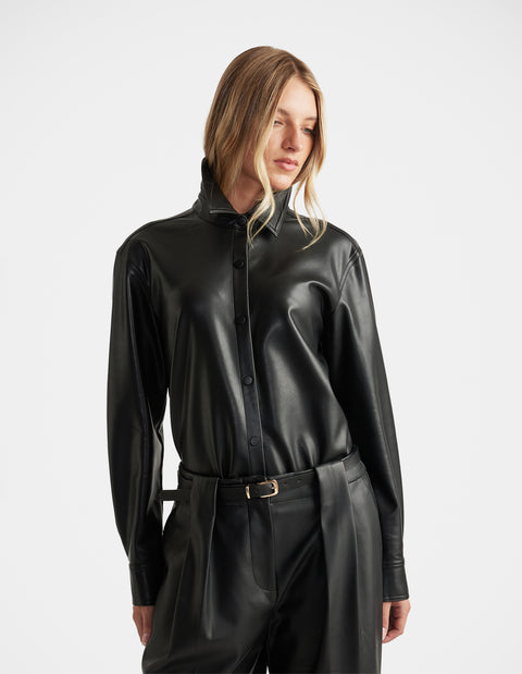 Woman wearing Jemma Faux Leather Shirt in black with a sleek button-up front and classic collar by DECJUBA.