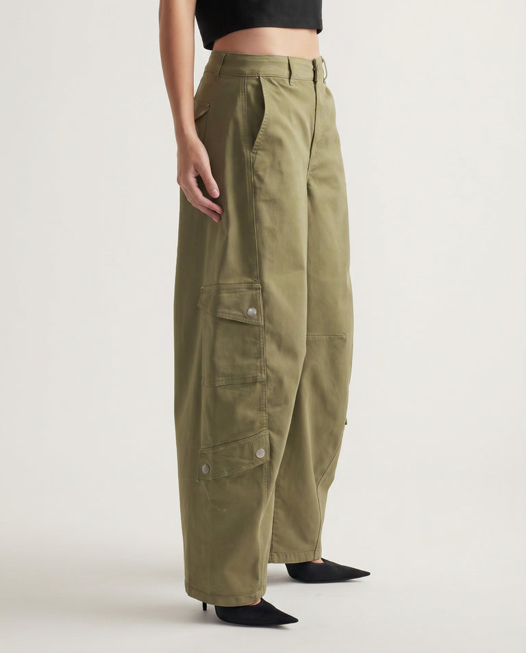 Woman wearing olive green wide-leg cargo pants paired with black pointed heels and a cropped top