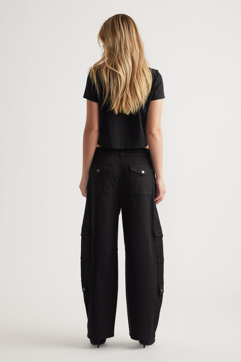 Woman wearing black cargo pants with buttoned back and side pockets paired with a fitted black cropped tee