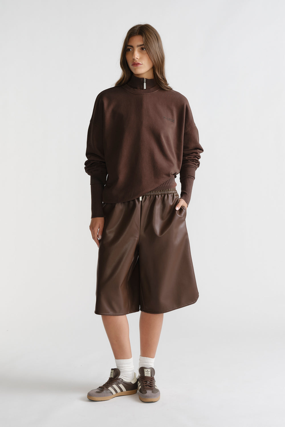 Woman wearing D-Luxe Washed Terry Sweat in rich walnut brown with high neck and ribbed cuffs for relaxed, stylish comfort