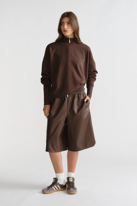 Woman wearing D-Luxe Washed Terry Sweat in rich walnut brown with high neck and ribbed cuffs for relaxed, stylish comfort