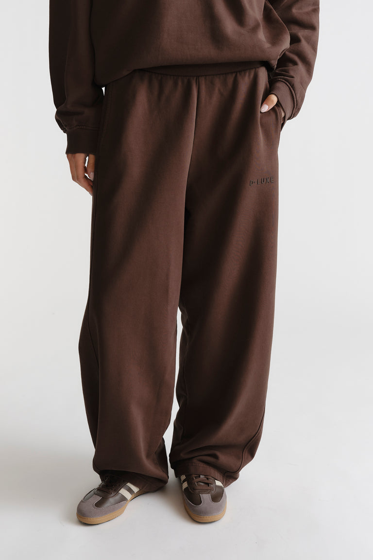 D-Luxe Washed Trackpant in warm walnut brown with relaxed fit, elastic waist, and subtle branded detail by DECJUBA.