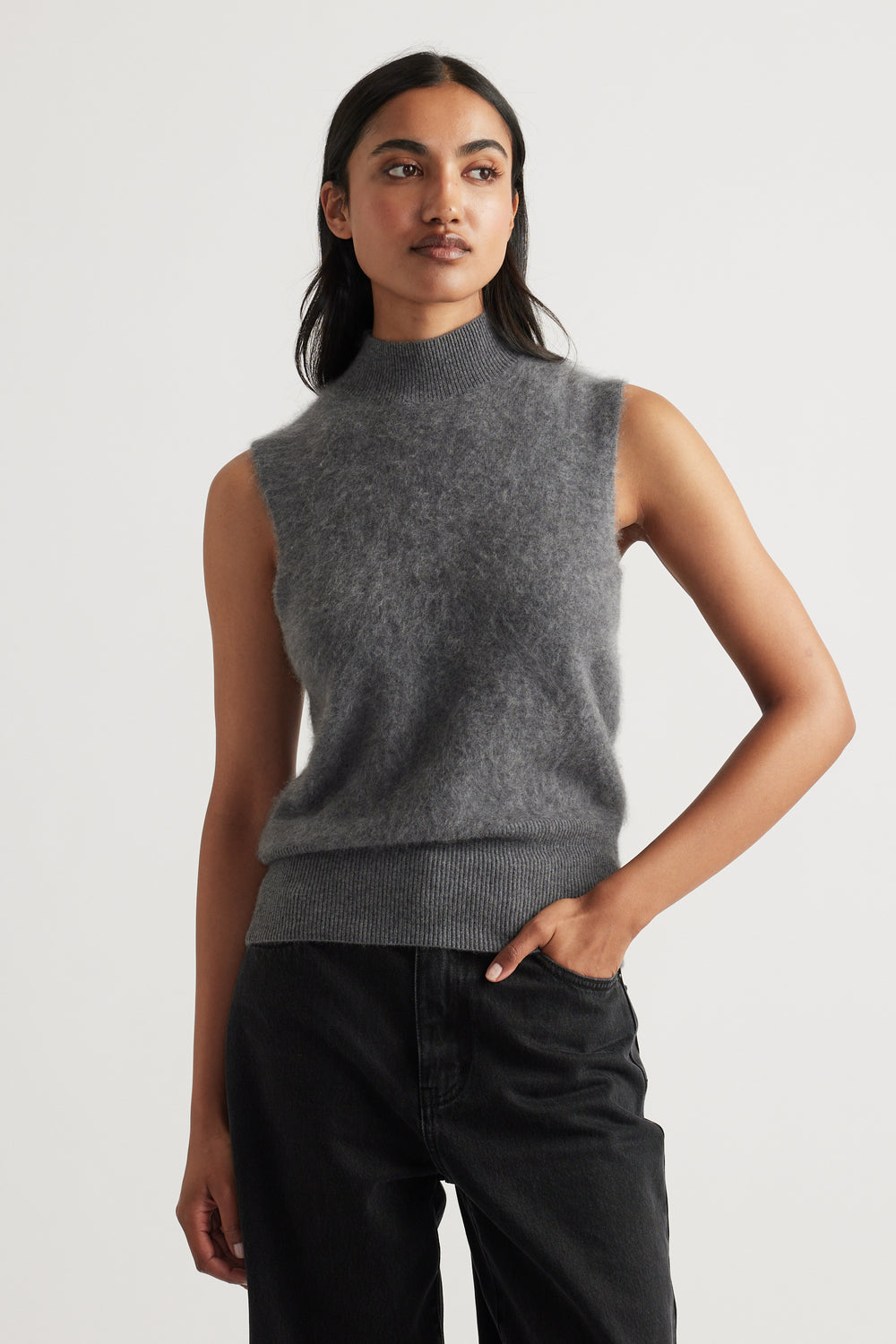 Sleeveless charcoal wool knit vest with a soft, cozy texture styled with relaxed black pants for a modern look
