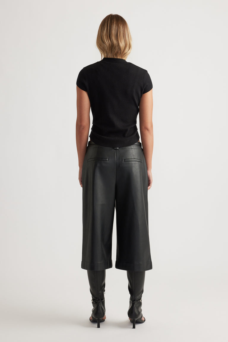 Back view of Lily Pleat Detail Knit Tee in black, paired with wide-leg cropped leather pants and heeled boots.