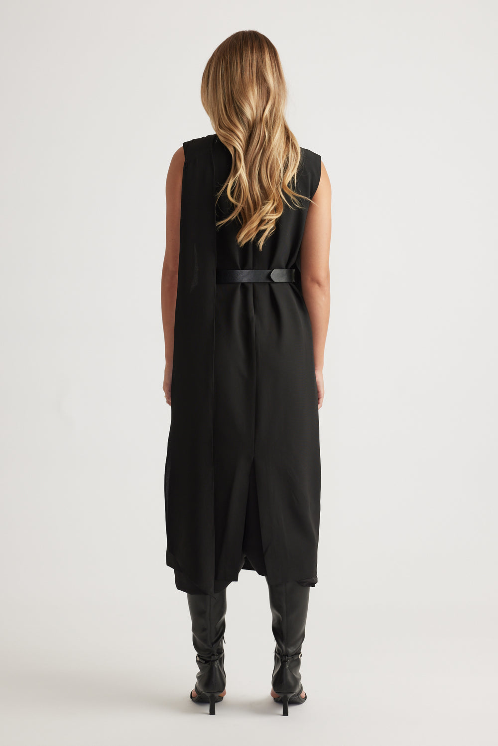 Woman shown from behind wearing Isla Overlay Midi Dress in black with sleeveless design and belted waist by DECJUBA