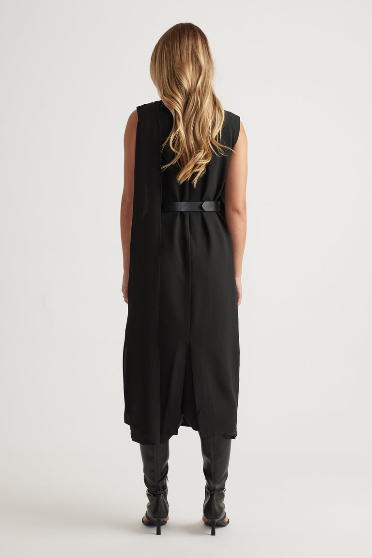 Woman shown from behind wearing Isla Overlay Midi Dress in black with sleeveless design and belted waist by DECJUBA