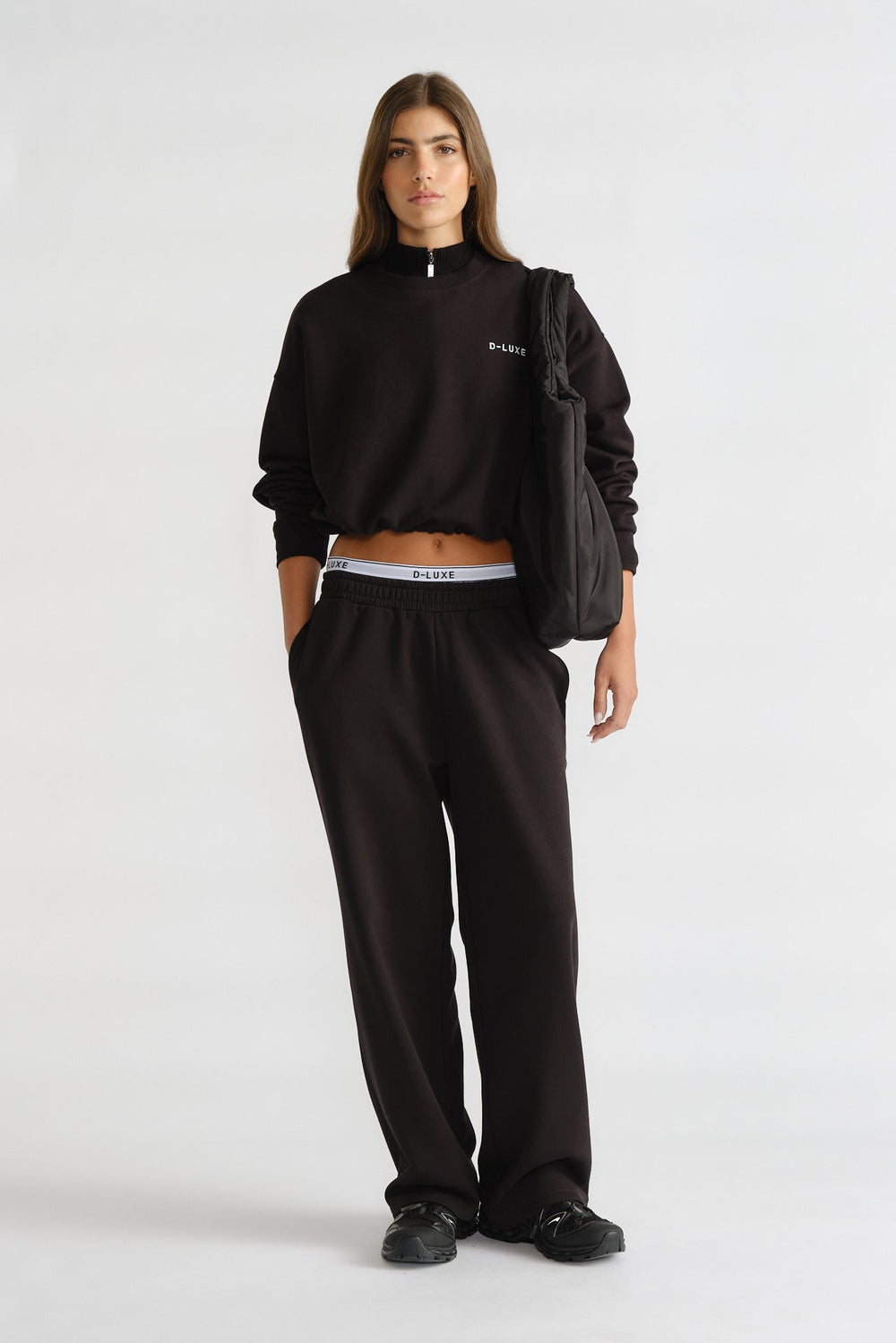 D-Luxe Logo Trackpant in black with relaxed fit, styled with matching cropped sweatshirt and casual sneakers by DECJUBA