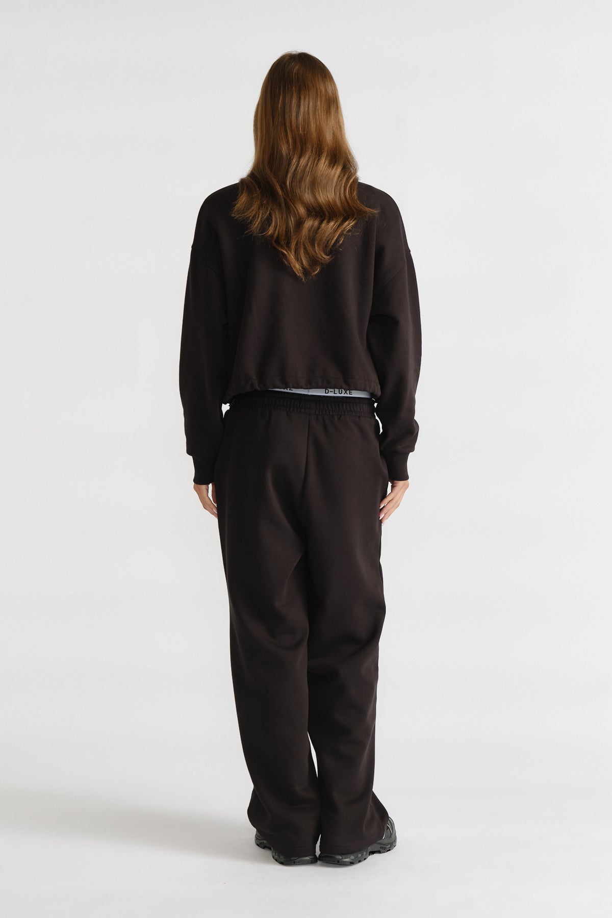 D-Luxe Logo Crop Sweat in black with a relaxed cropped fit, styled with matching black pants for a casual look by DECJUBA