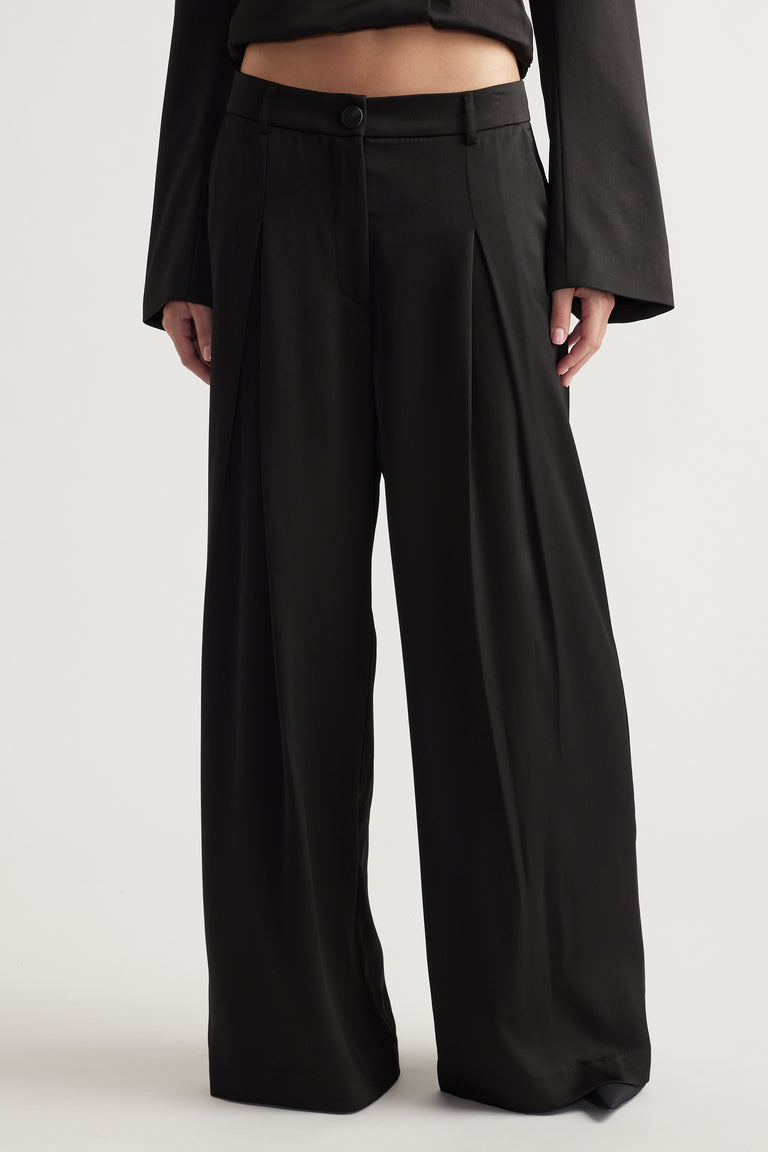 High-waisted black wide-leg pants with a front button and pleated detail for a relaxed fit.