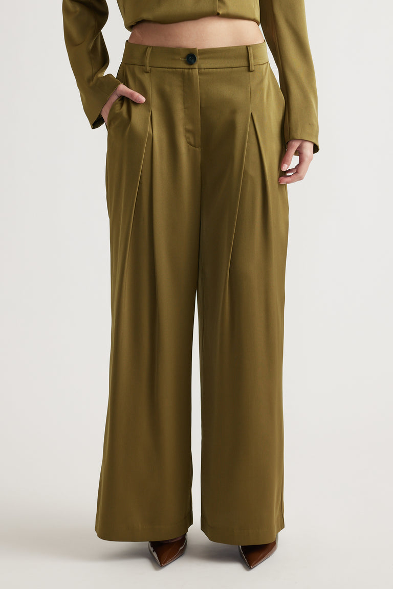 High-waisted wide leg pants in muted green with front pleats and side pockets styled with matching top.