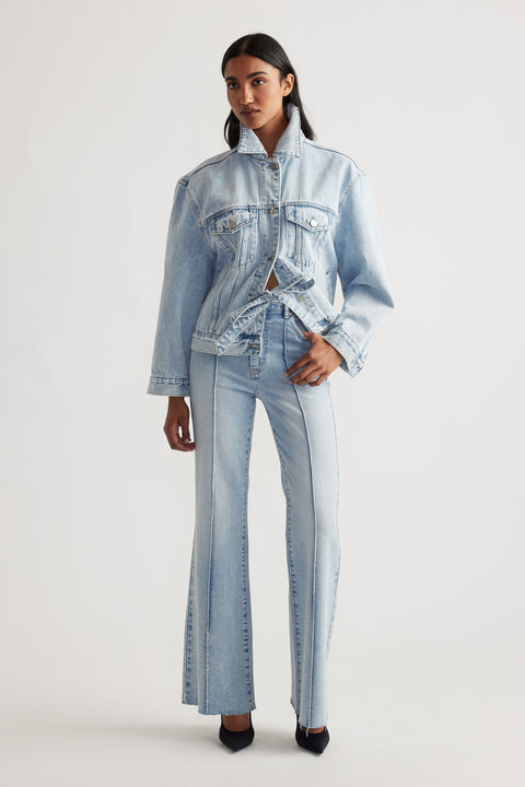 Woman wearing light blue Freya Flare Jean styled with matching denim jacket and black heels for a modern casual look by DECJUBA