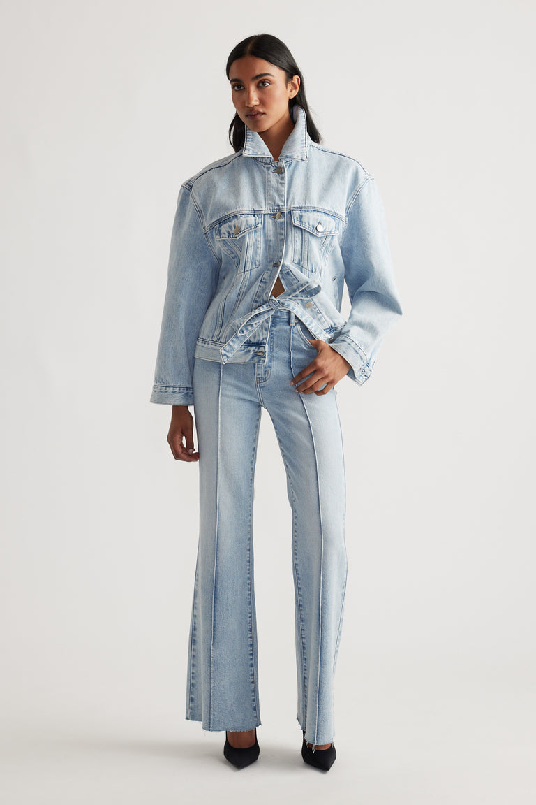 Woman wearing light blue Freya Flare Jean styled with matching denim jacket and black heels for a modern casual look by DECJUBA