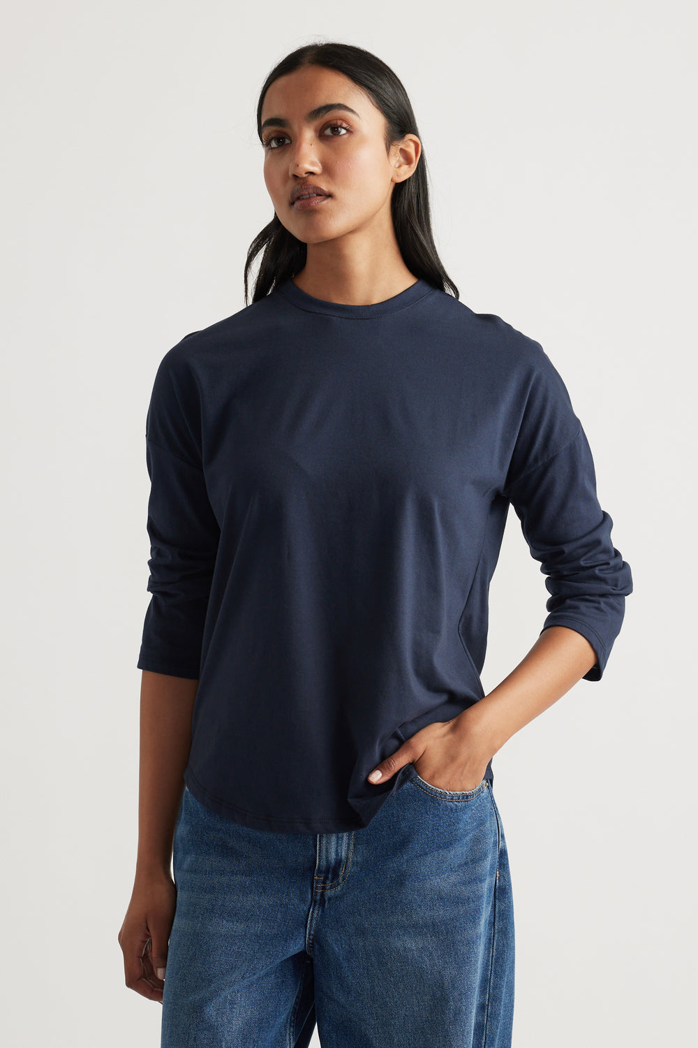 Woman wearing a classic navy long sleeve top paired with relaxed blue denim jeans for a timeless casual outfit