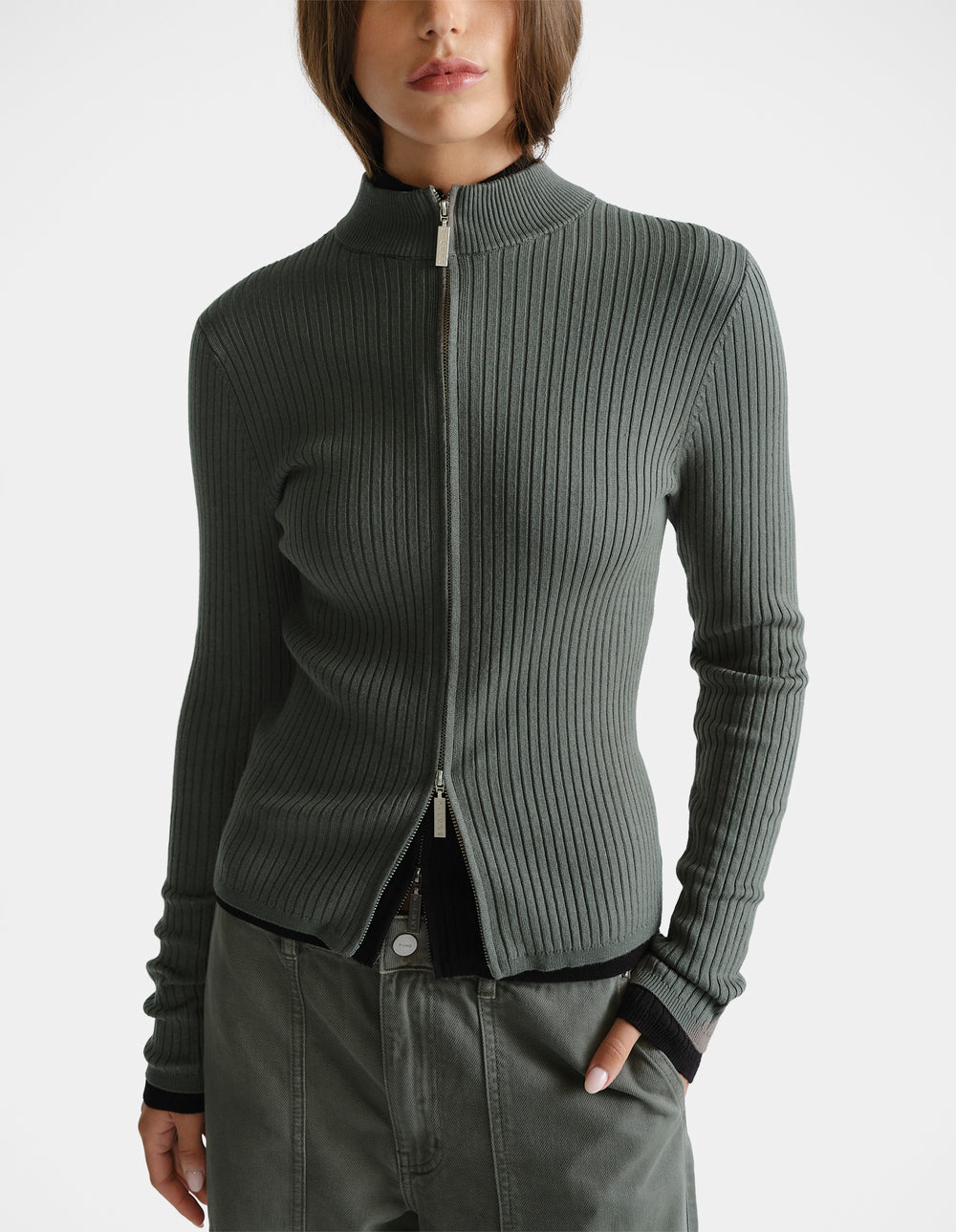 Woman wearing a thyme green D-Luxe Knit Zip Long Sleeve with ribbed texture and a sleek high collar for a modern look