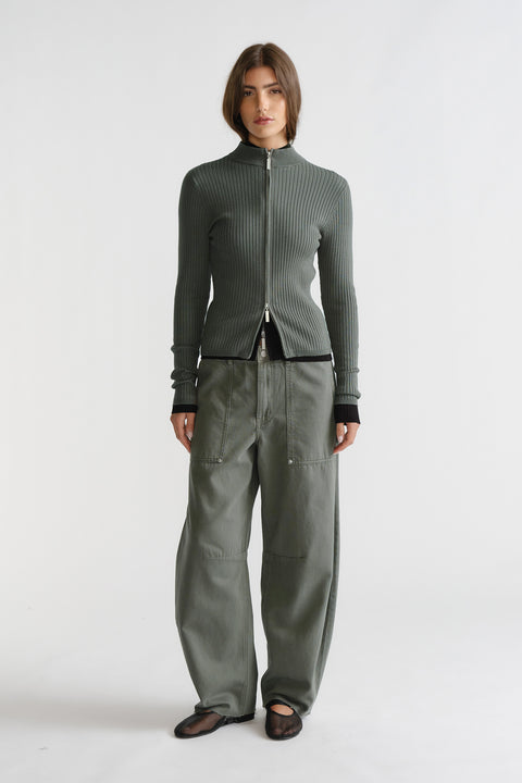 Woman wearing a thyme green D-Luxe Knit Zip Long Sleeve with ribbed texture paired with relaxed khaki pants by DECJUBA