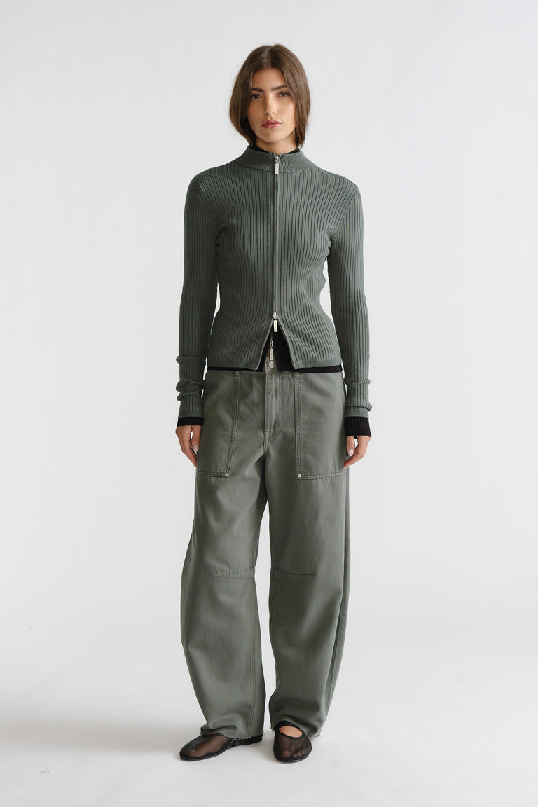 Woman wearing a thyme green D-Luxe Knit Zip Long Sleeve with ribbed texture paired with relaxed khaki pants by DECJUBA