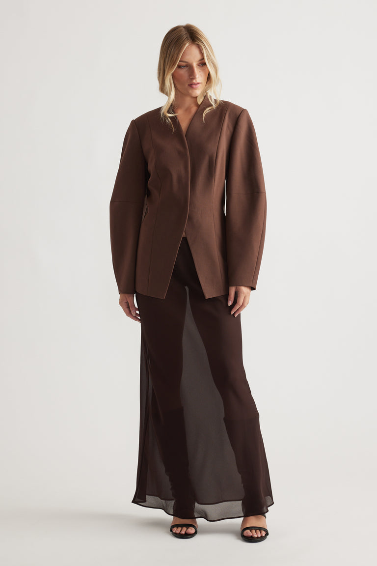 Woman wearing a chocolate brown Ruby Barrel Sleeve Blazer styled with a sheer dark maxi skirt and black open-toe heels