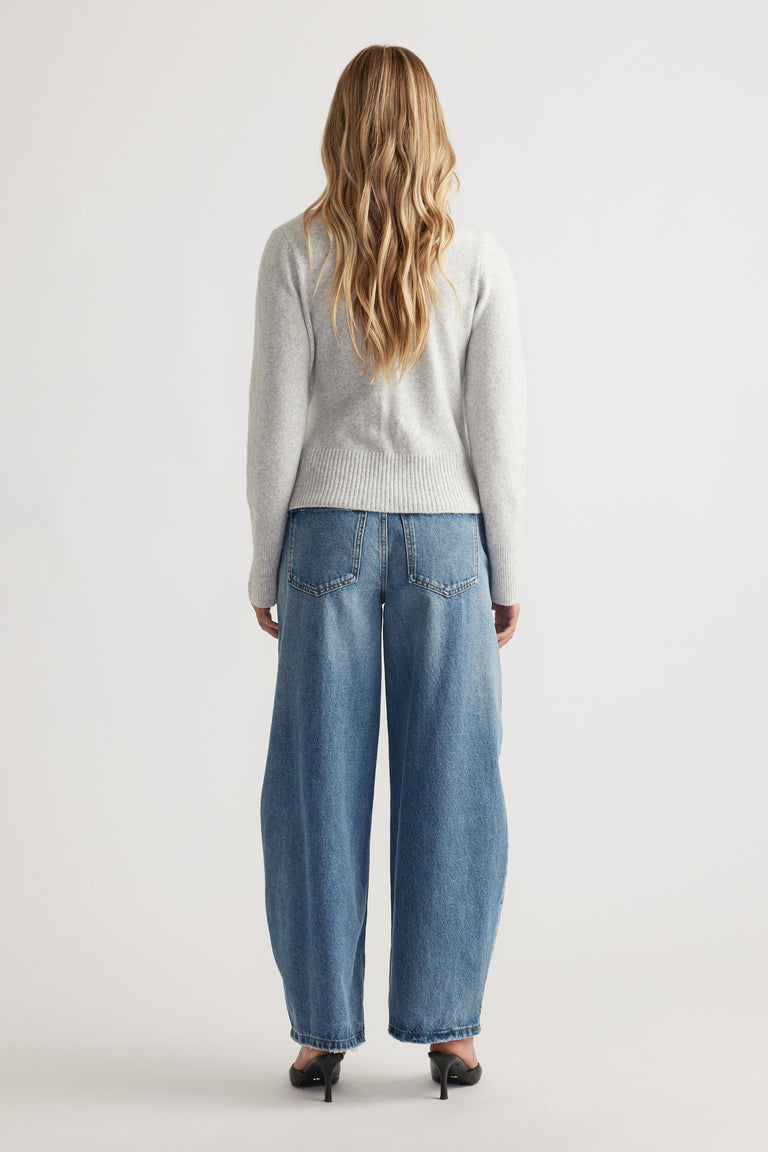 Back view of woman wearing Tamica Layered Jumper in soft grey paired with relaxed wide-leg blue jeans and black heels