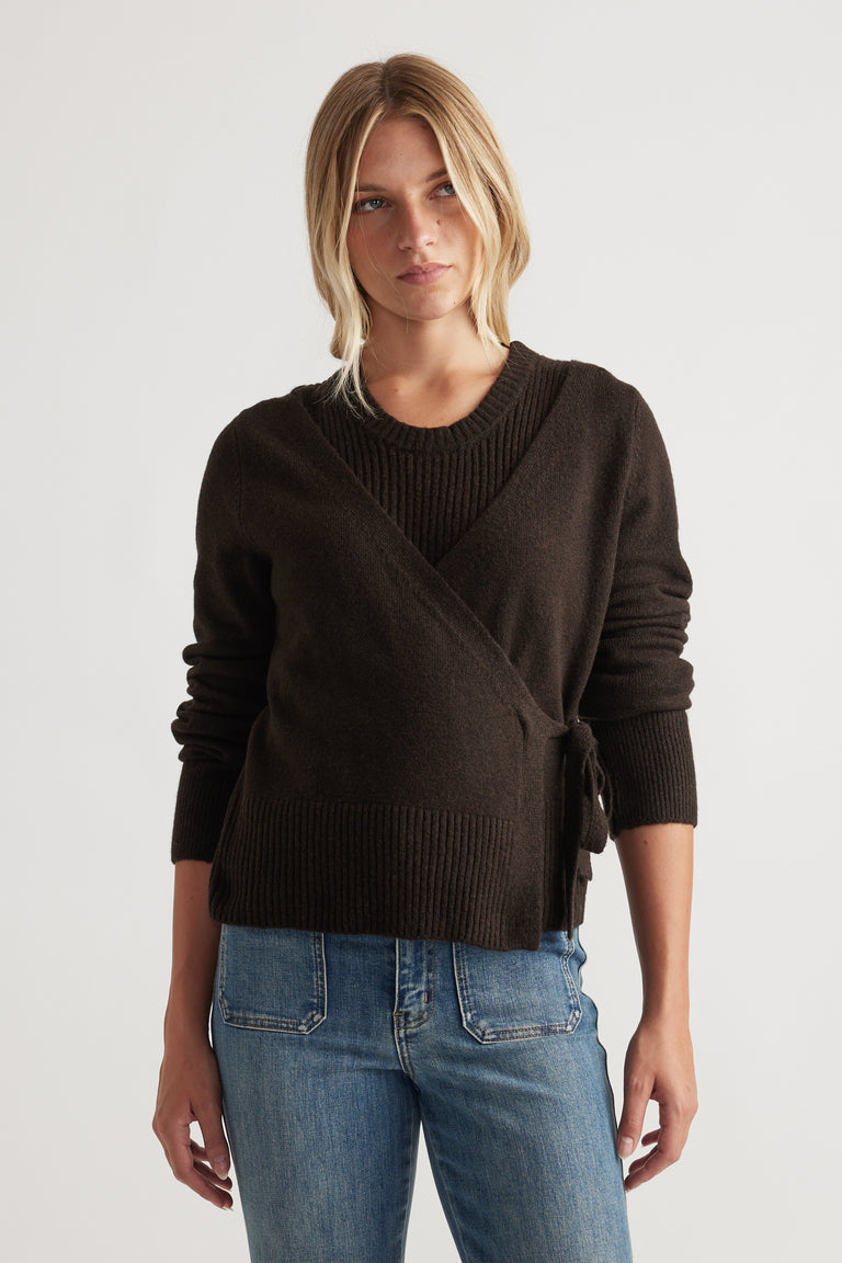 Woman wearing Tamica Layered Jumper in soft truffle brown with wrap tie detail and ribbed accents styled with blue jeans by DECJUBA
