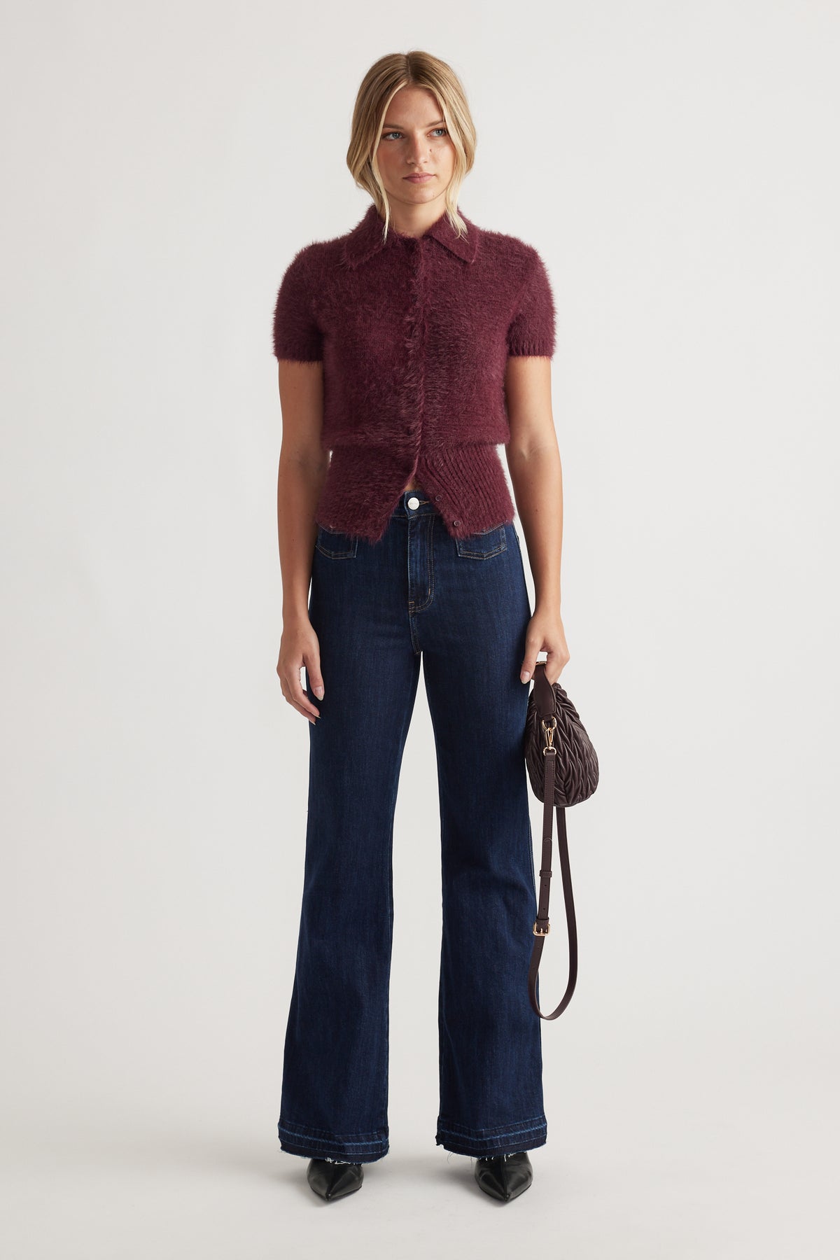 Front view of Rosie Fluffy Knit Polo Tee in deep plum paired with dark wide-leg denim jeans and black pointed shoes.
