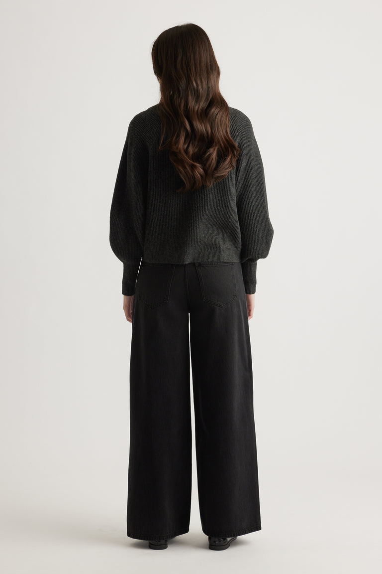 Woman wearing a charcoal knit cardigan with balloon sleeves styled with wide-leg black pants for a relaxed look