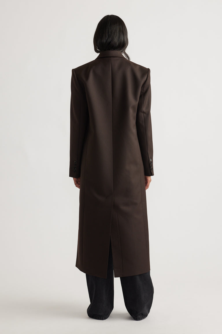 Back view of woman wearing Ella Blazer Coat in rich brown with tailored fit and longline silhouette for timeless elegance.