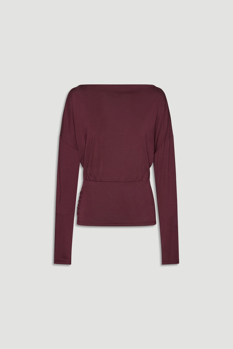 Plum-colored long sleeve top with a cinched waist, featuring a relaxed fit and soft drape for everyday elegance
