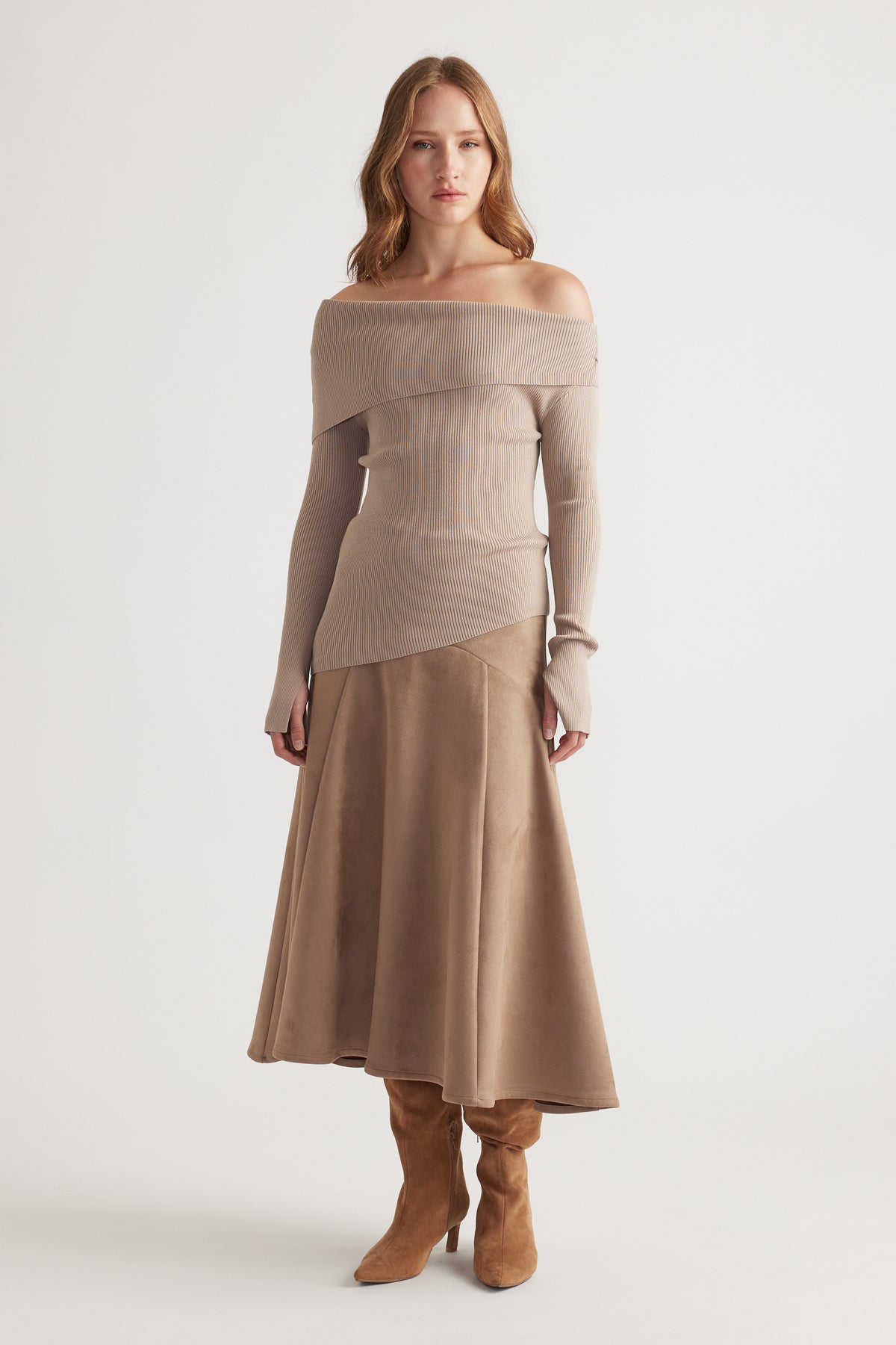 Woman wearing a taupe off-shoulder knit top paired with a flared suede midi skirt and tan suede boots