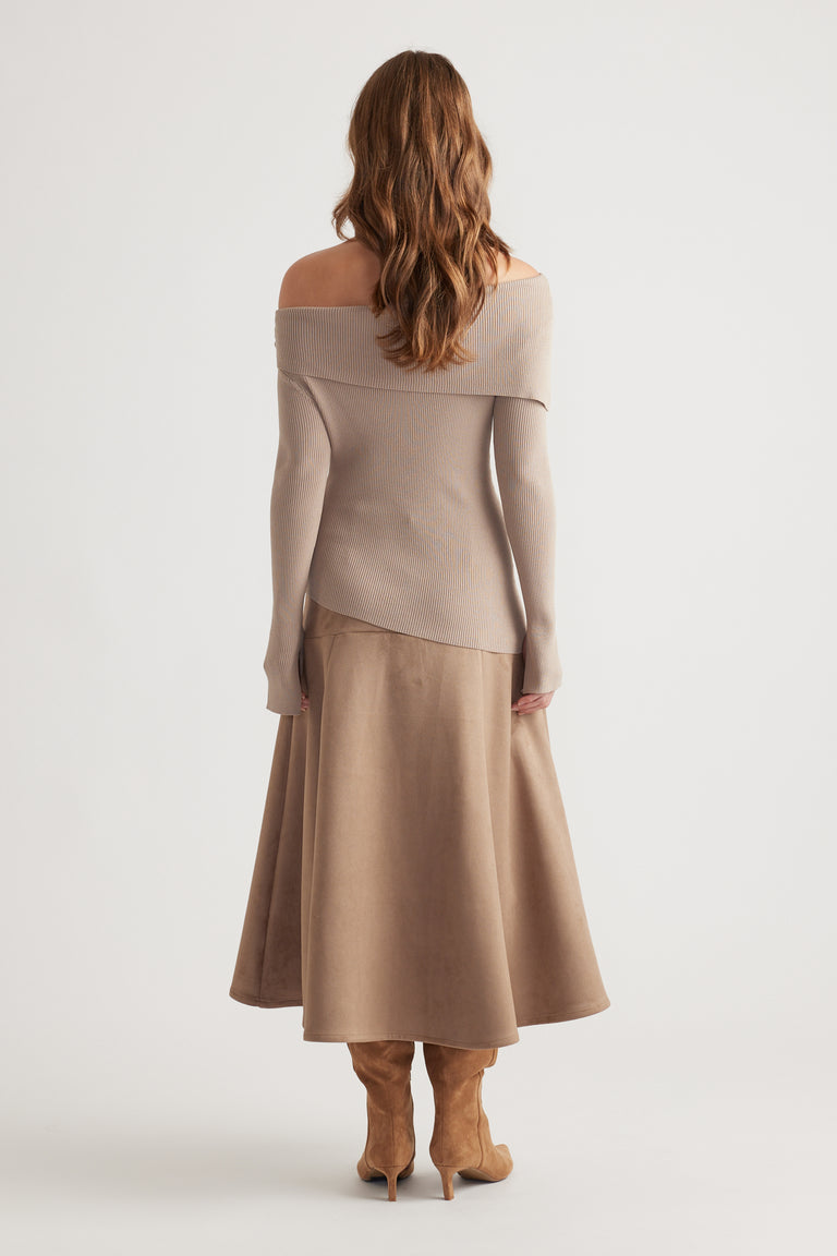 Back view of a soft biscuit-colored off-shoulder knit top paired with a flowing midi skirt and tan suede boots