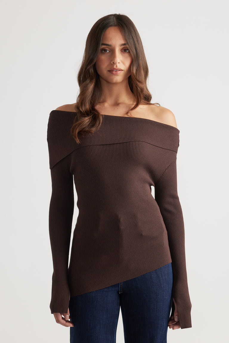 Fitted rich mocha ribbed knit top with asymmetrical off-shoulder neckline paired with dark blue jeans