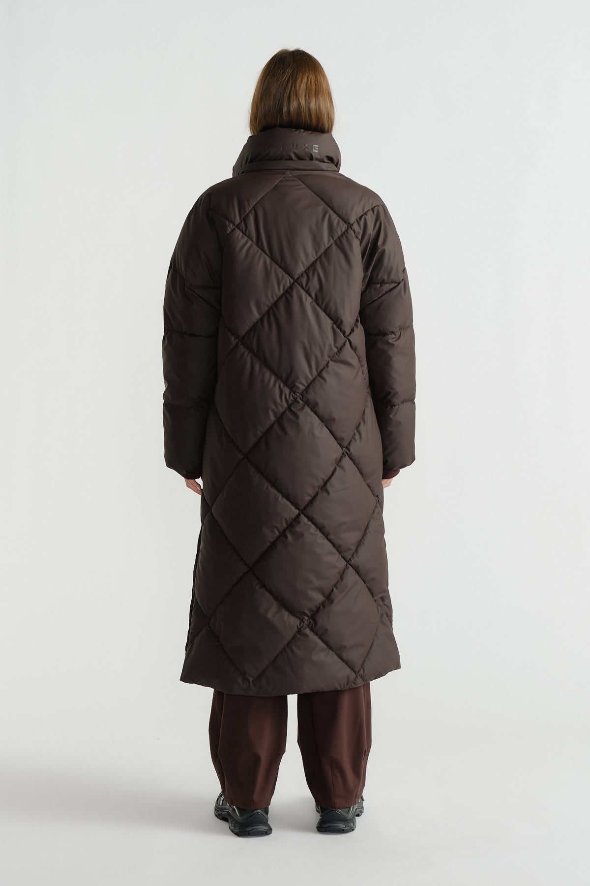 Back view of a long cocoa brown maxi puffer coat with diamond quilting and a high padded collar.