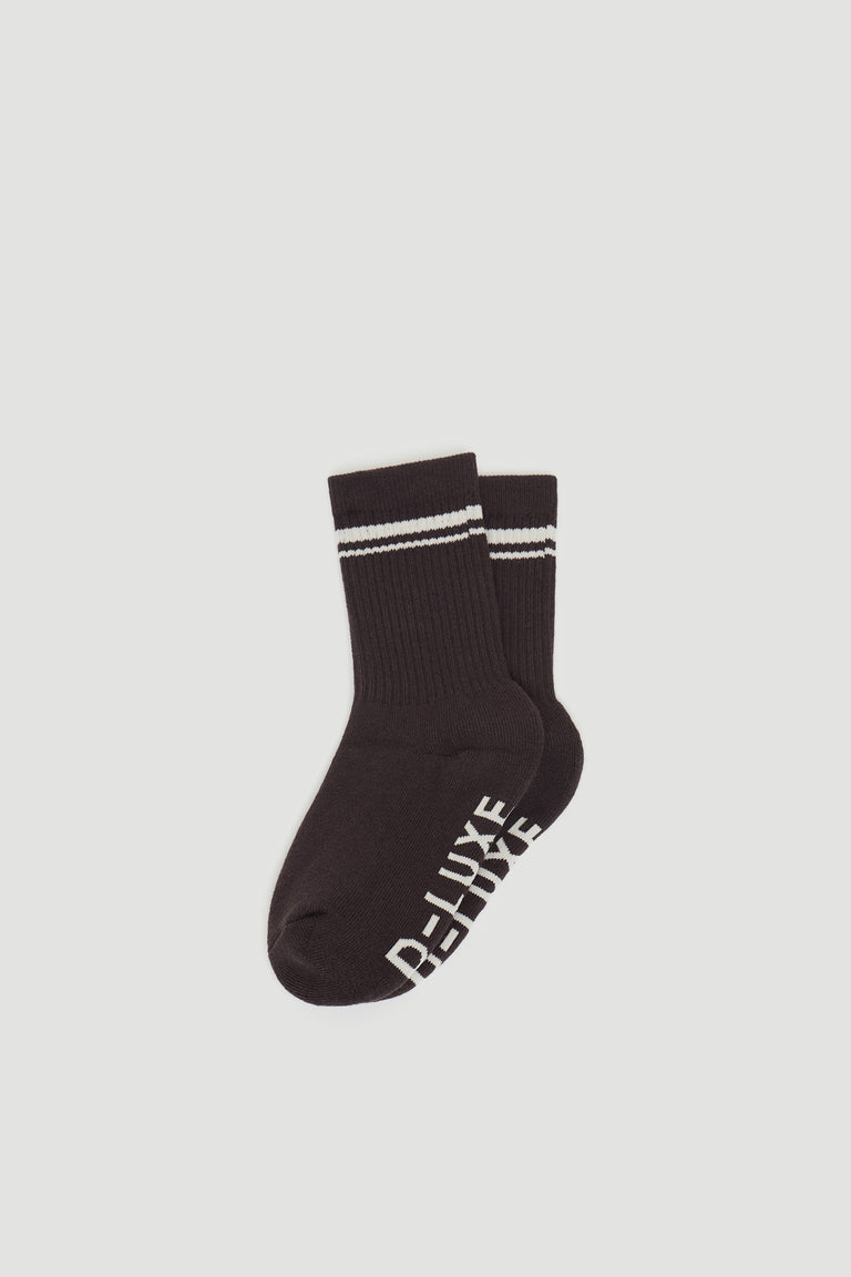 Pair of dark ribbed sports socks featuring white double stripes at the cuff and branded text on the sole.