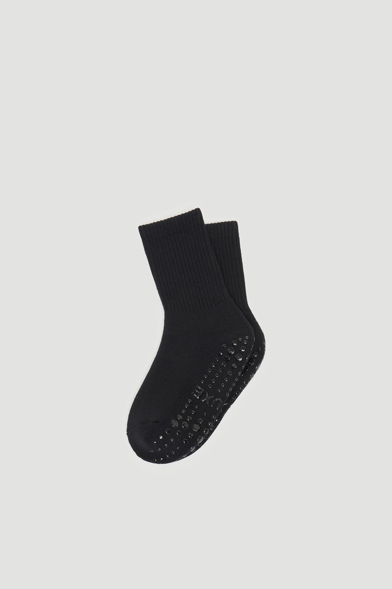 Pair of black grip socks with textured non-slip soles and a comfortable ribbed ankle cuff design