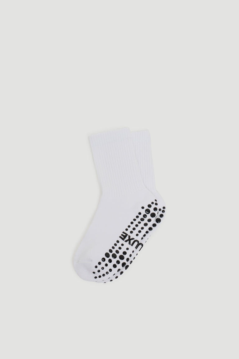 White crew socks featuring black grip dots on the sole for extra traction and comfortable everyday wear