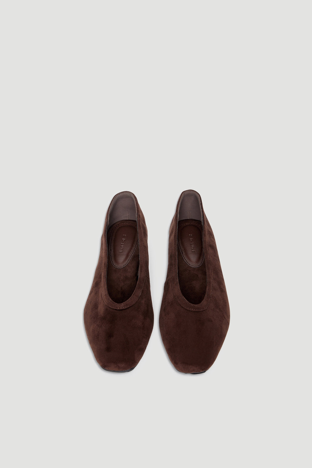 Pair of chocolate microsuede ballet flats with round toe and smooth texture shown from above against light background