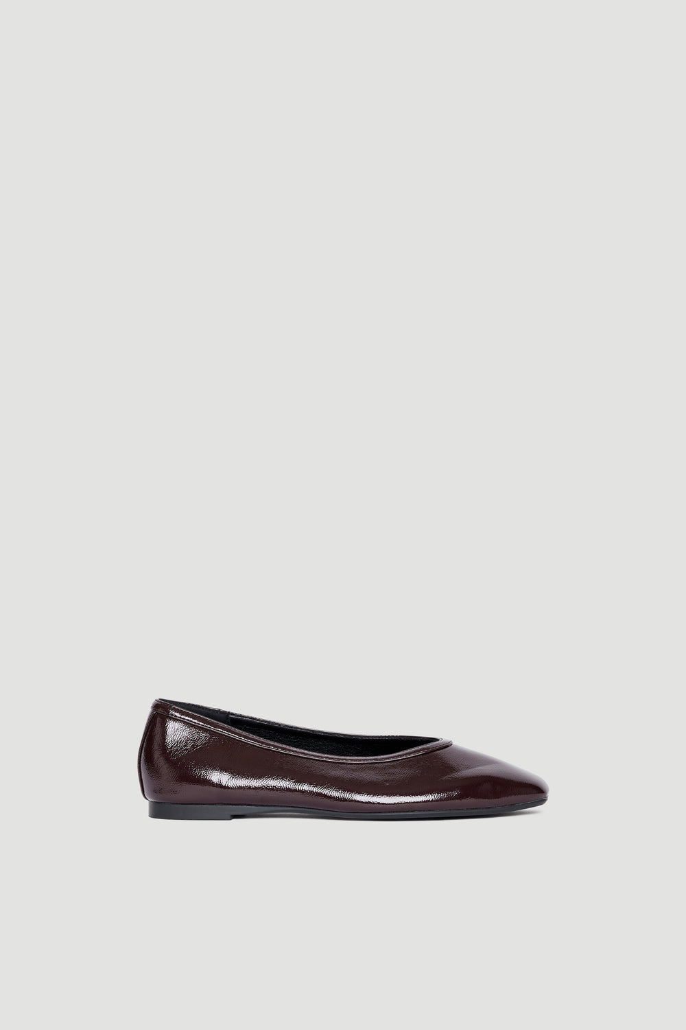 Side profile of a sleek dark brown ballet flat with a rounded toe and smooth finish against a neutral background