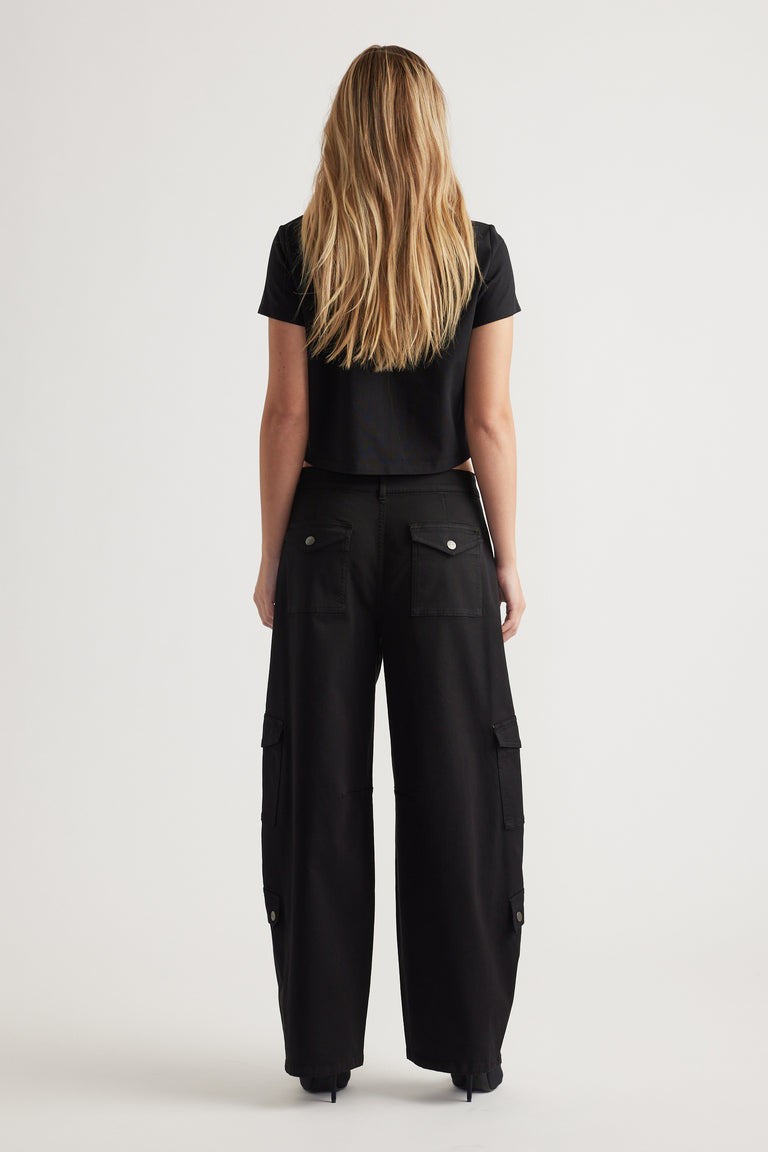 Woman wearing a black cropped tee paired with wide-leg black cargo pants featuring flap pockets, back view.