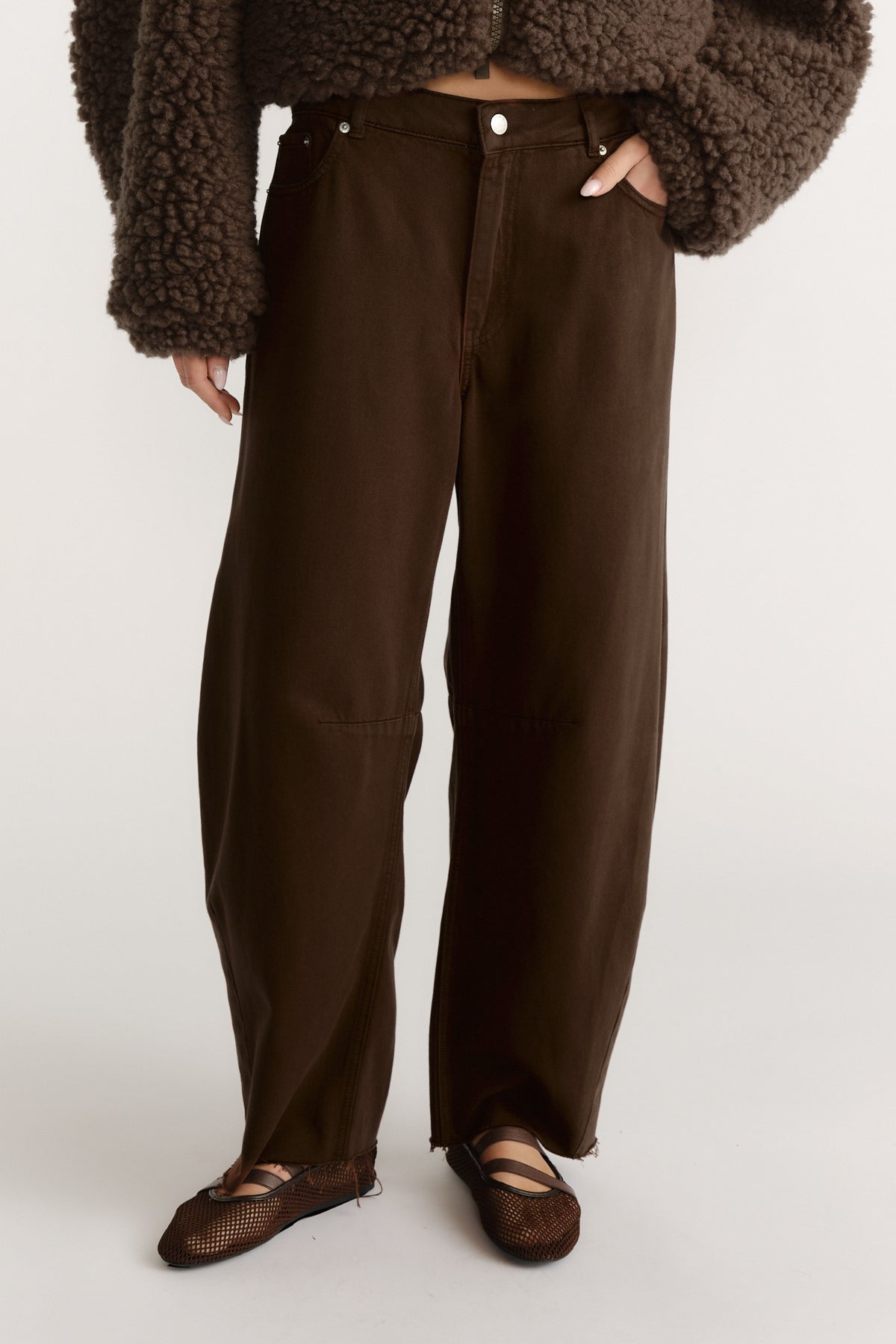 High-waist wide-leg brown jeans paired with a textured dark brown cropped jacket and mesh ballet flats