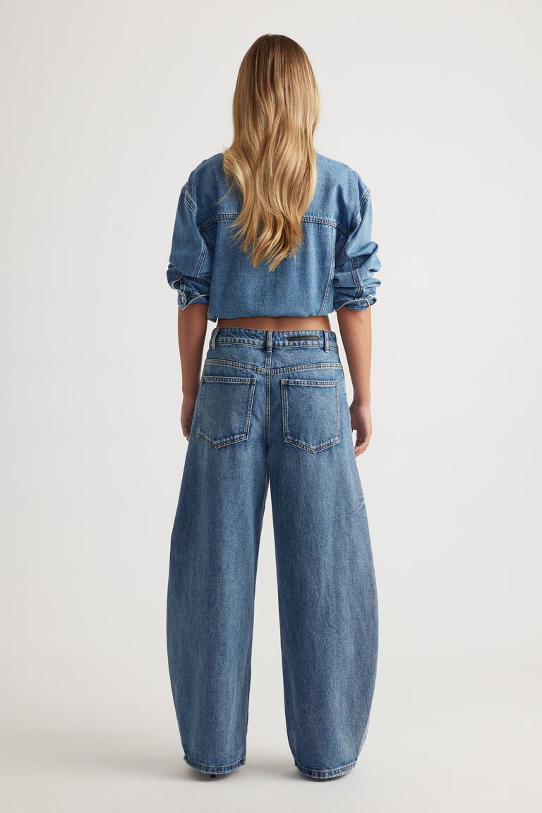 Woman wearing a cropped denim jacket with high rise horseshoe leg jeans