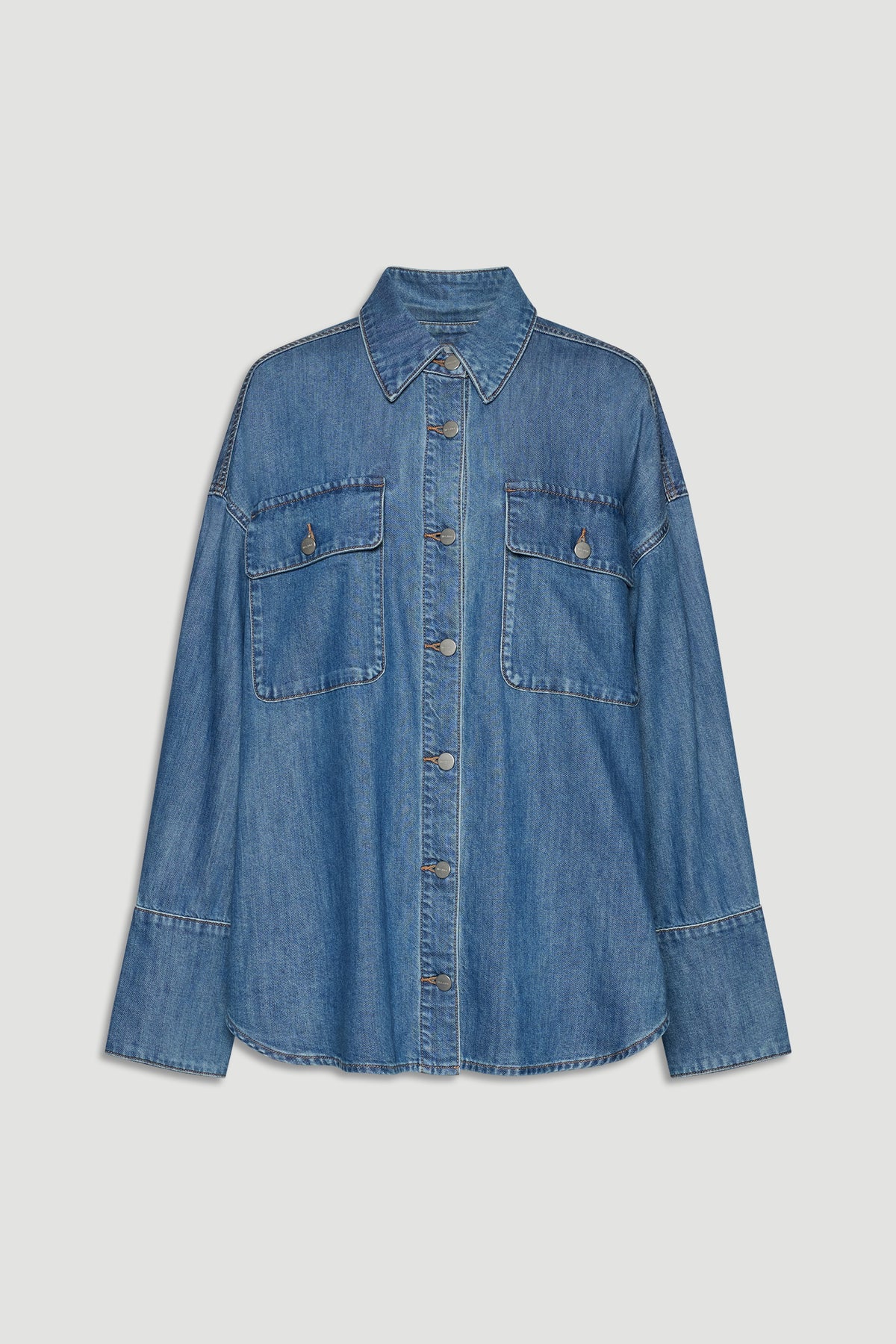 Blue denim shirt with button front, pointed collar, and two large chest pockets for a relaxed, versatile look