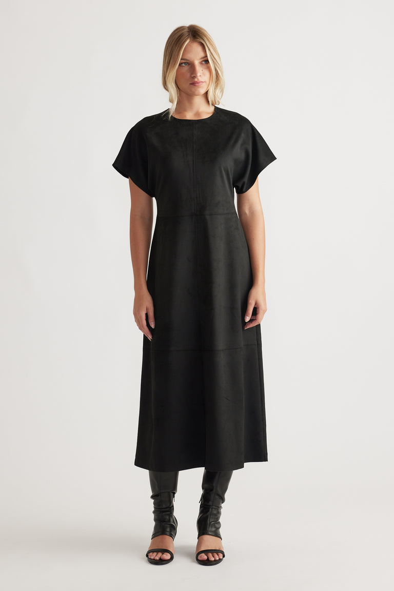 Woman wearing Clara Faux Suede Midi Dress in black with short sleeves and a streamlined silhouette for elegant versatility
